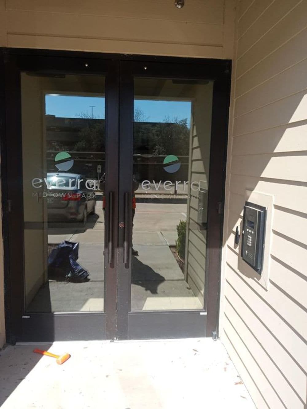 Entrance of Everra Midtown Park with glass double doors and intercom system.